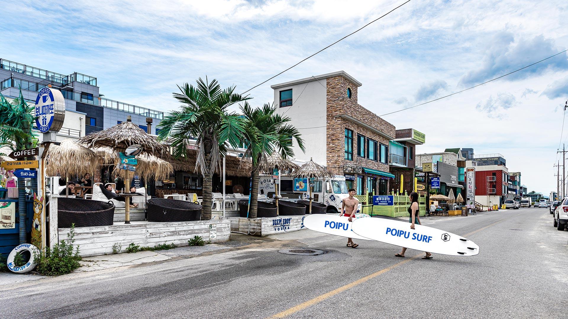 People entering the shop carrying surfboards