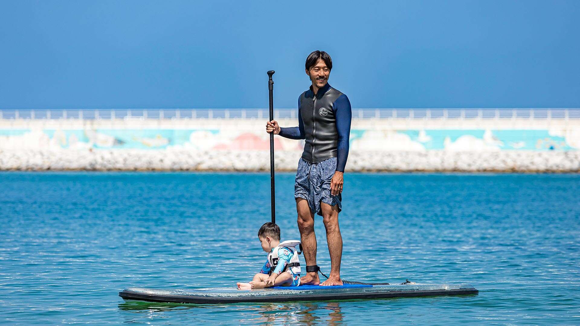 People enjoying paddleboarding with their children 01